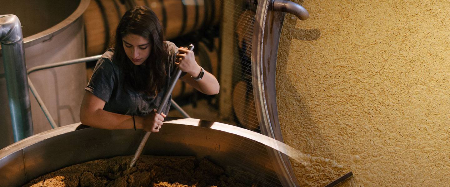 Women stirs batch of whiskey.